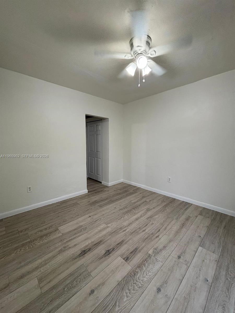 200 Northwest 13th Street, Unit 5 Miami, FL 33136 - Photo 7 of 9 a view of an empty room with wooden floor