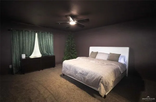 a spacious bedroom with a bed and a chandelier