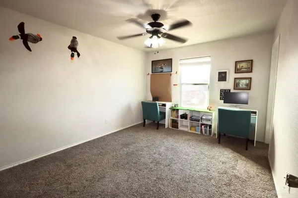 a view of a workspace with furniture and a window
