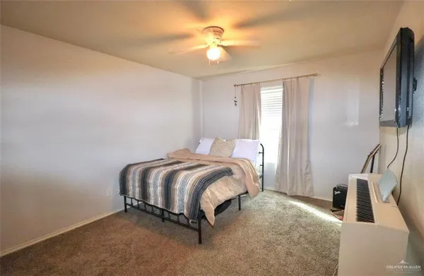 a spacious bedroom with a bed and a chandelier