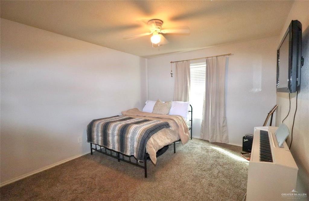 10731 North 29th Lane McAllen, TX 78504 - Photo 22 of 28 a spacious bedroom with a bed and a chandelier