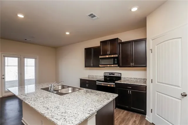 a kitchen with stainless steel appliances granite countertop a sink stove and refrigerator