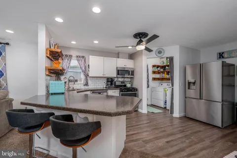 a kitchen with stainless steel appliances granite countertop a sink a refrigerator and a refrigerator