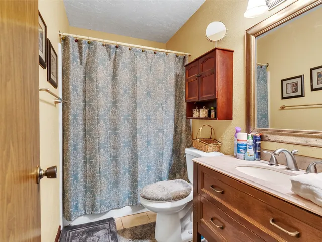 a bathroom with a toilet a sink and mirror