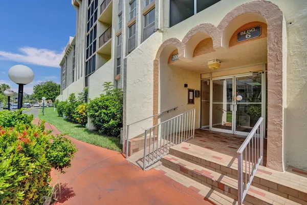 a view of a house with a large window and plants