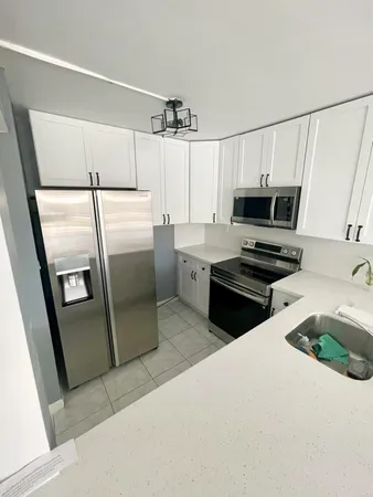 a kitchen with a refrigerator a stove and a sink