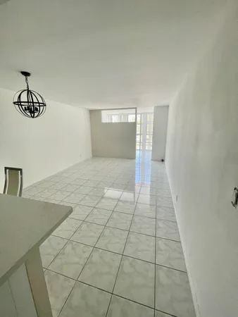 en empty room with windows and cabinet