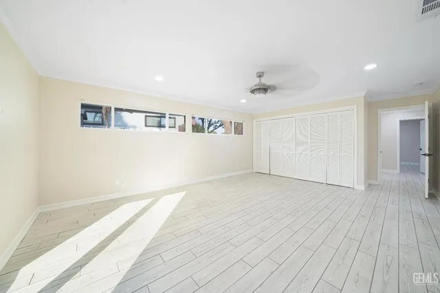 a view of empty room with wooden floor and windows