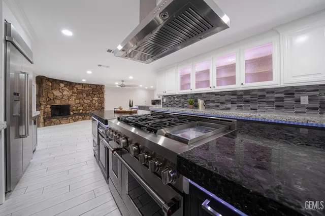 a kitchen with stove and wooden floor