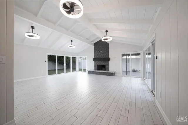 a view of an empty room with a fireplace and a window