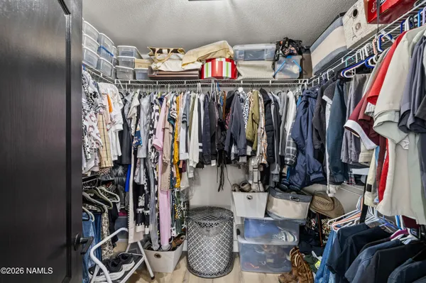 a view of walk in closet with clothes