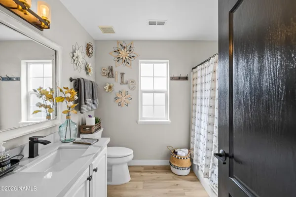 a bathroom with a granite countertop toilet a sink and a mirror
