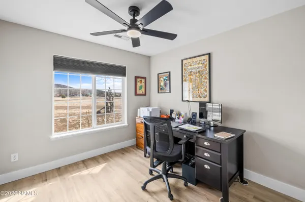 a view of a workspace with furniture and a window