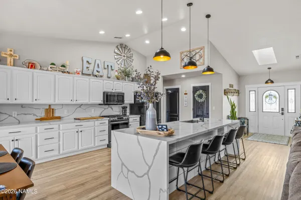 a kitchen with stainless steel appliances kitchen island granite countertop a stove a sink and a refrigerator