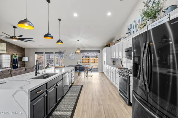a kitchen with counter top space appliances and wooden floor