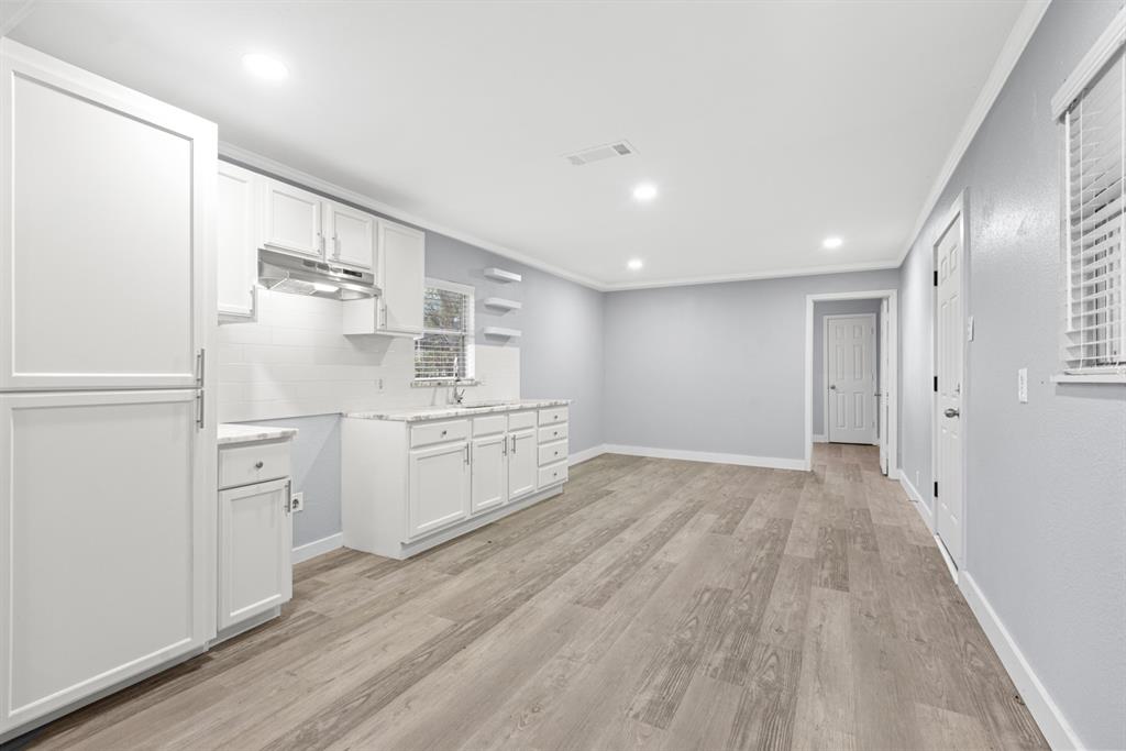 10474 Apache Street Wills Point, TX 75169 - Photo 10 of 29 a view of a kitchen with white cabinets and wooden floor