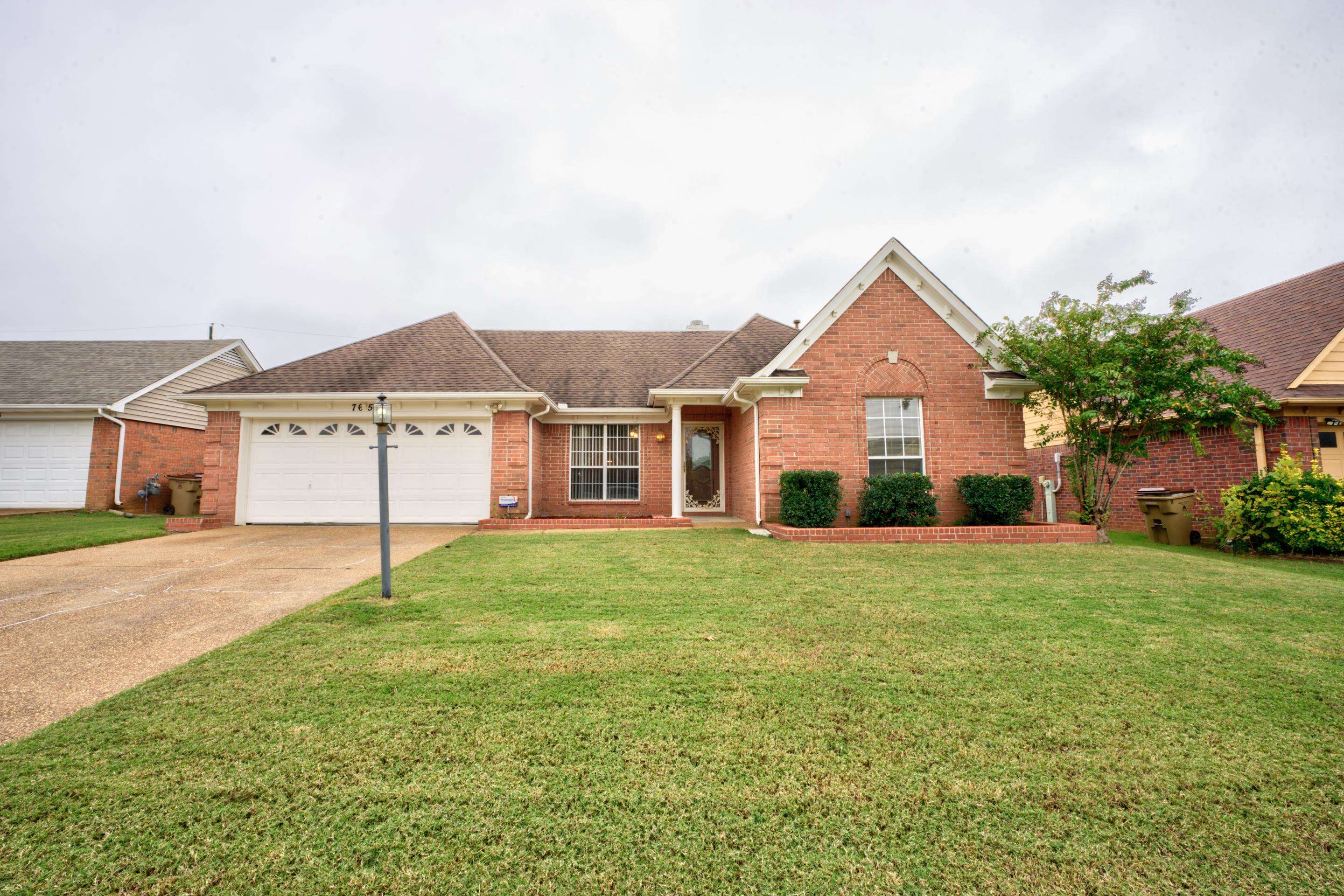 7657 Stone Manor Road Memphis, TN 38125 - Photo 1 of 27 Ranch-style home with a garage and a front lawn