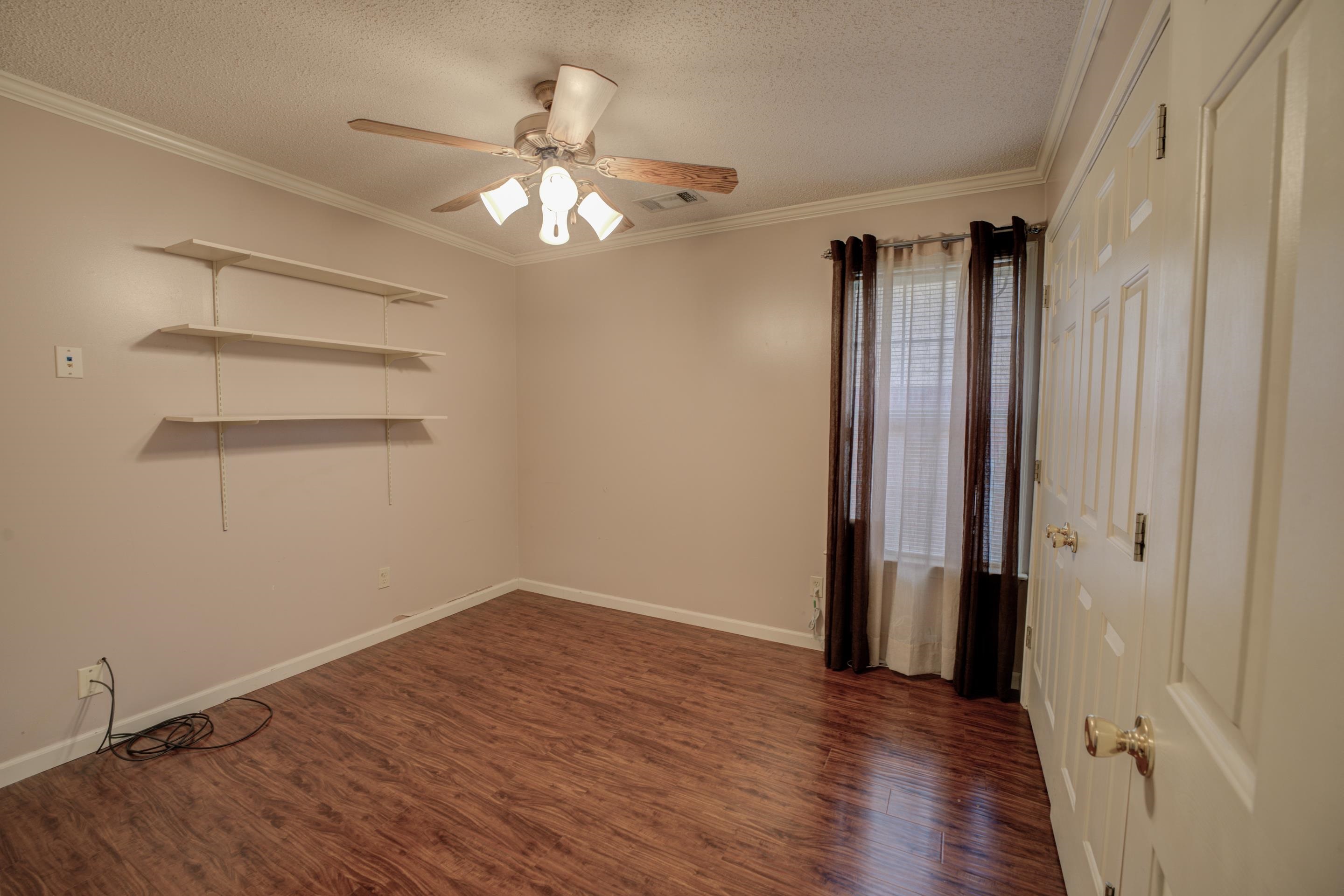 7657 Stone Manor Road Memphis, TN 38125 - Photo 16 of 27 Empty room featuring ceiling fan, a textured ceiling, dark hardwood / wood-style flooring, and ornamental molding