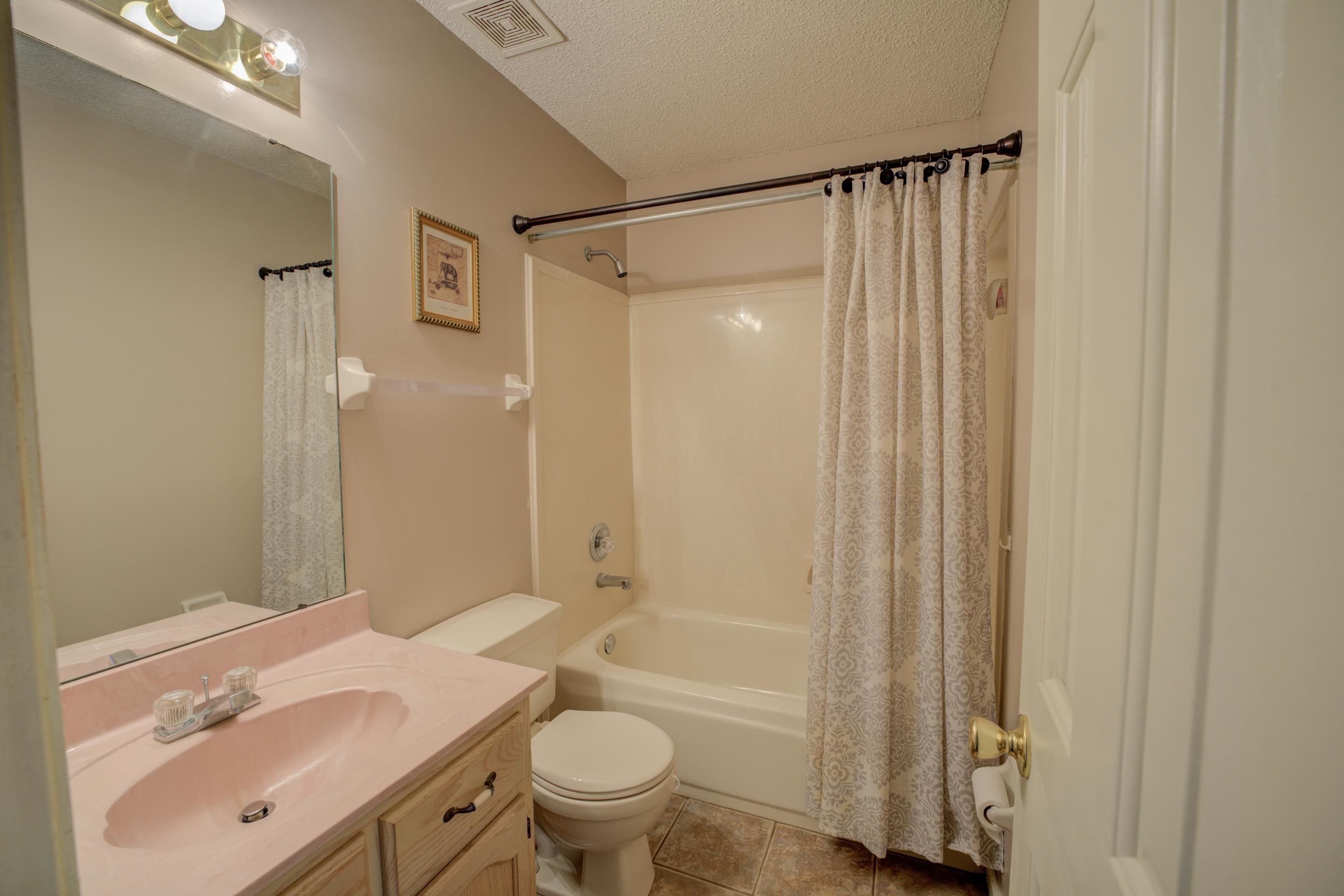 7657 Stone Manor Road Memphis, TN 38125 - Photo 18 of 27 Full bathroom featuring tile patterned floors, vanity, a textured ceiling, toilet, and shower / bath combo with shower curtain