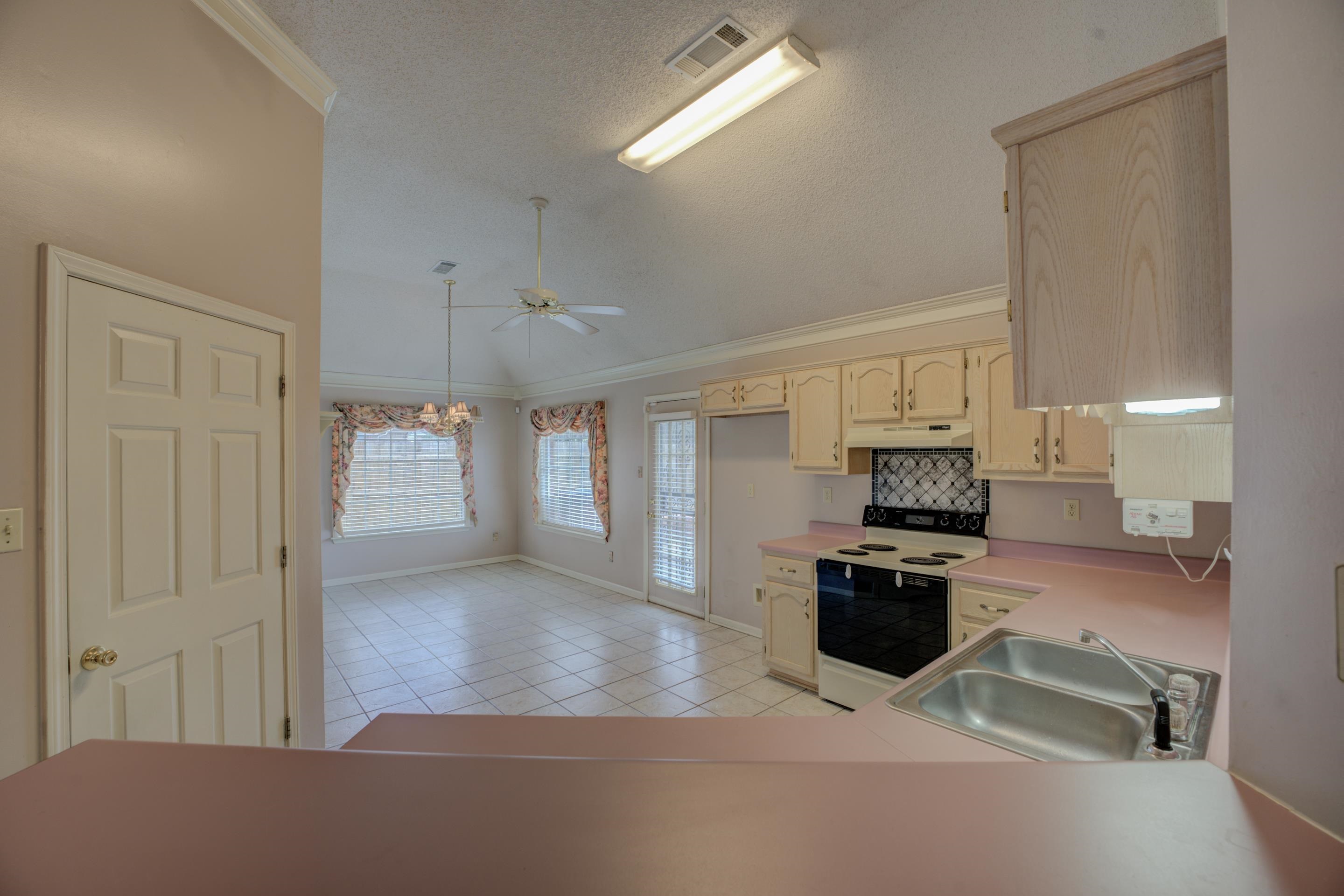 7657 Stone Manor Road Memphis, TN 38125 - Photo 8 of 27 Kitchen with white electric range, sink, lofted ceiling, and ornamental molding