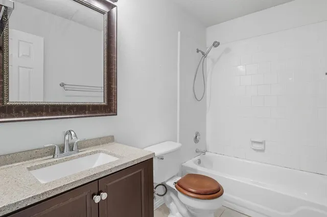 a bathroom with a granite countertop toilet sink and mirror
