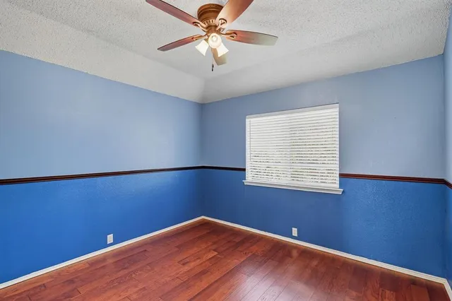 a view of a big room with wooden floor and windows