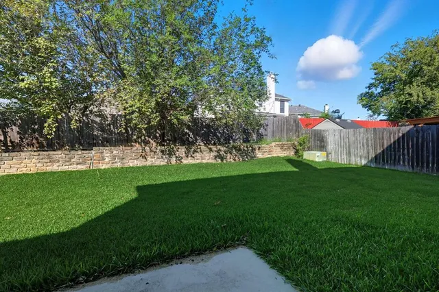 a view of green field with trees in the background