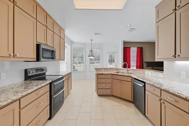 a kitchen with stainless steel appliances granite countertop a stove sink and cabinets