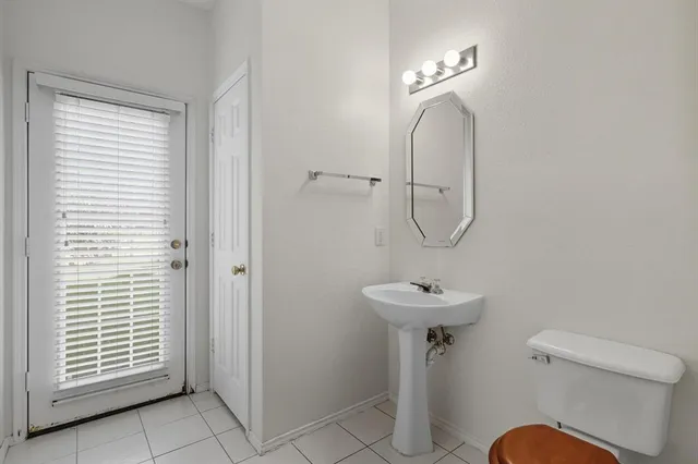 a bathroom with a sink a toilet and a mirror