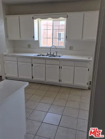 a kitchen with stainless steel appliances a sink window and cabinets