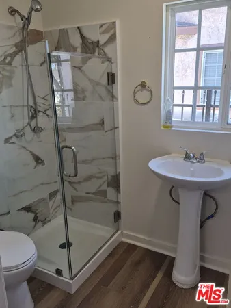 a bathroom with a shower sink and mirror