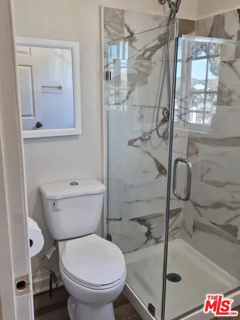 a bathroom with a toilet and a shower