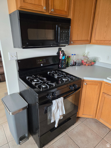 343 300 North, Unit 9 Provo, UT 84601 - Photo 7 of 10 Kitchen with black appliances, light countertops, wood finish cabinets, and light tile patterned floors