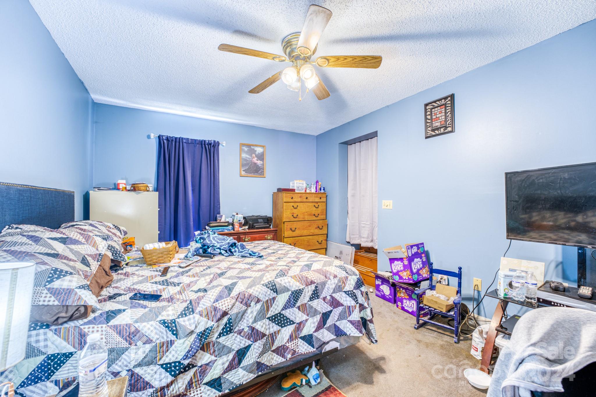 1 Westgate Road Asheville, NC 28806 - Photo 17 of 25 a bedroom with a bed and a chandelier