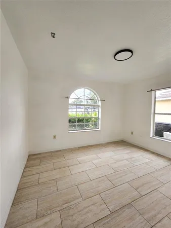 an empty room with a fireplace and windows
