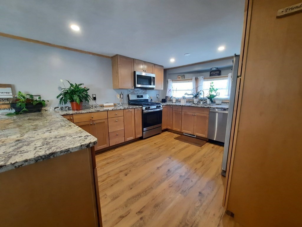 270 Littleton Road, Unit 182 Chelmsford, MA 01824 - Photo 8 of 22 a kitchen with stainless steel appliances granite countertop a stove a sink and a refrigerator