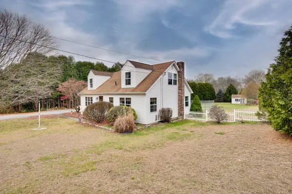 a house that has a table and chairs in front of it