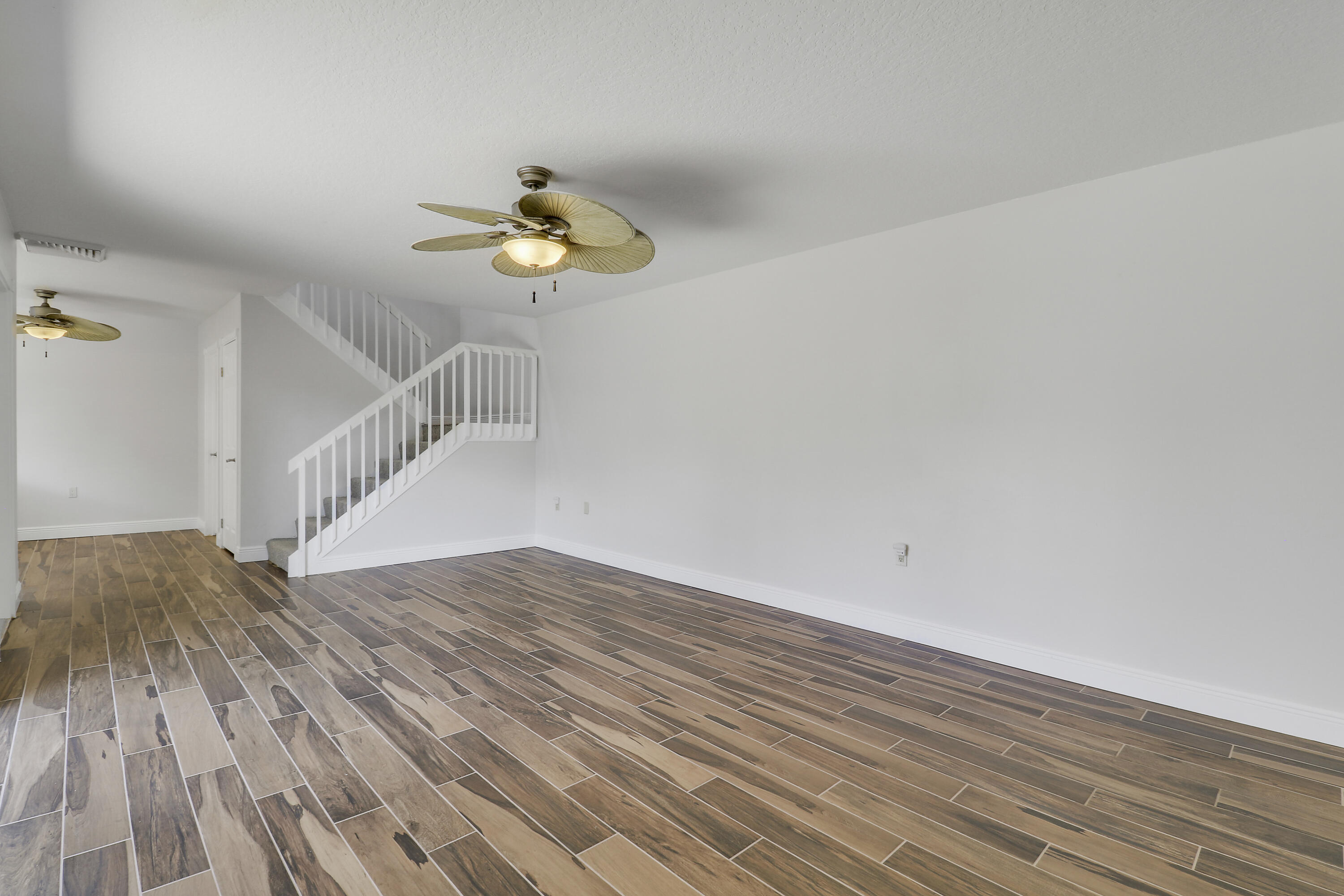 2324 23rd Court, Unit 55D Jupiter, FL 33477 - Photo 13 of 41 a view of a room with wooden floor ceiling fan and window