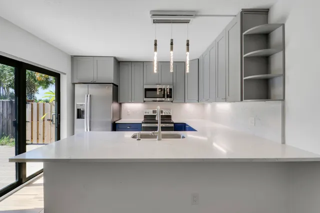 a kitchen with stainless steel appliances granite countertop a sink stove and microwave