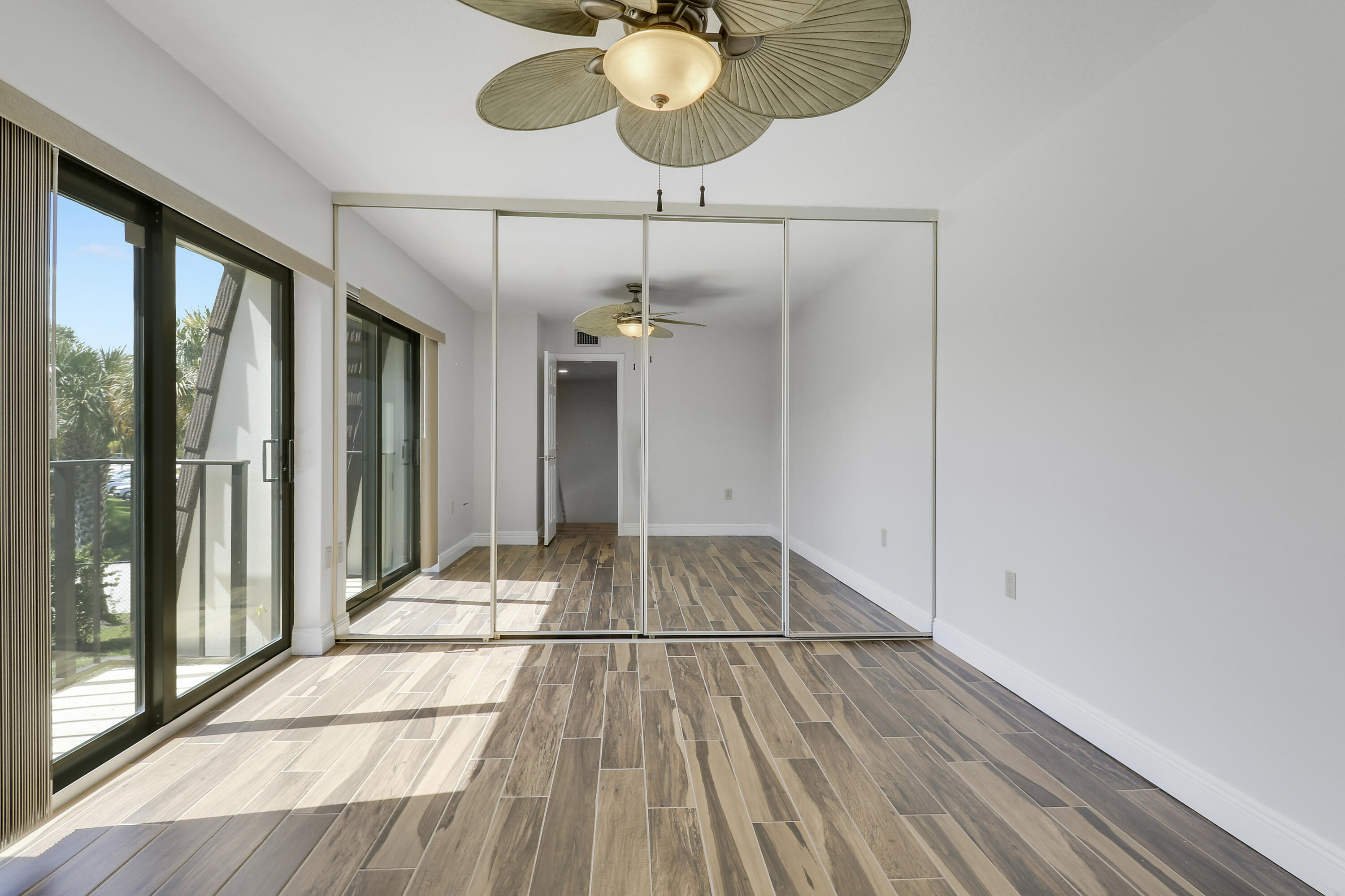2324 23rd Court, Unit 55D Jupiter, FL 33477 - Photo 23 of 41 a view of empty room with wooden floor and fan