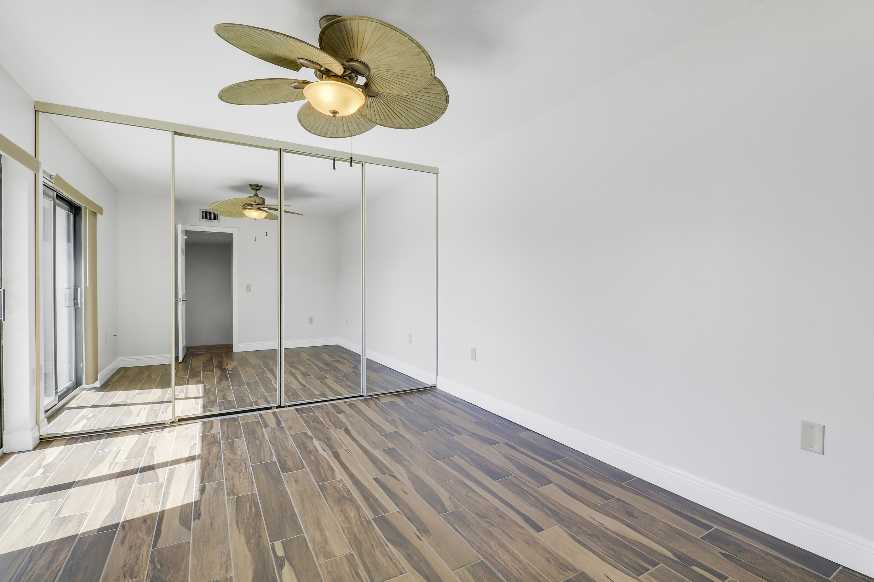 2324 23rd Court, Unit 55D Jupiter, FL 33477 - Photo 24 of 41 a view of an empty room with wooden floor