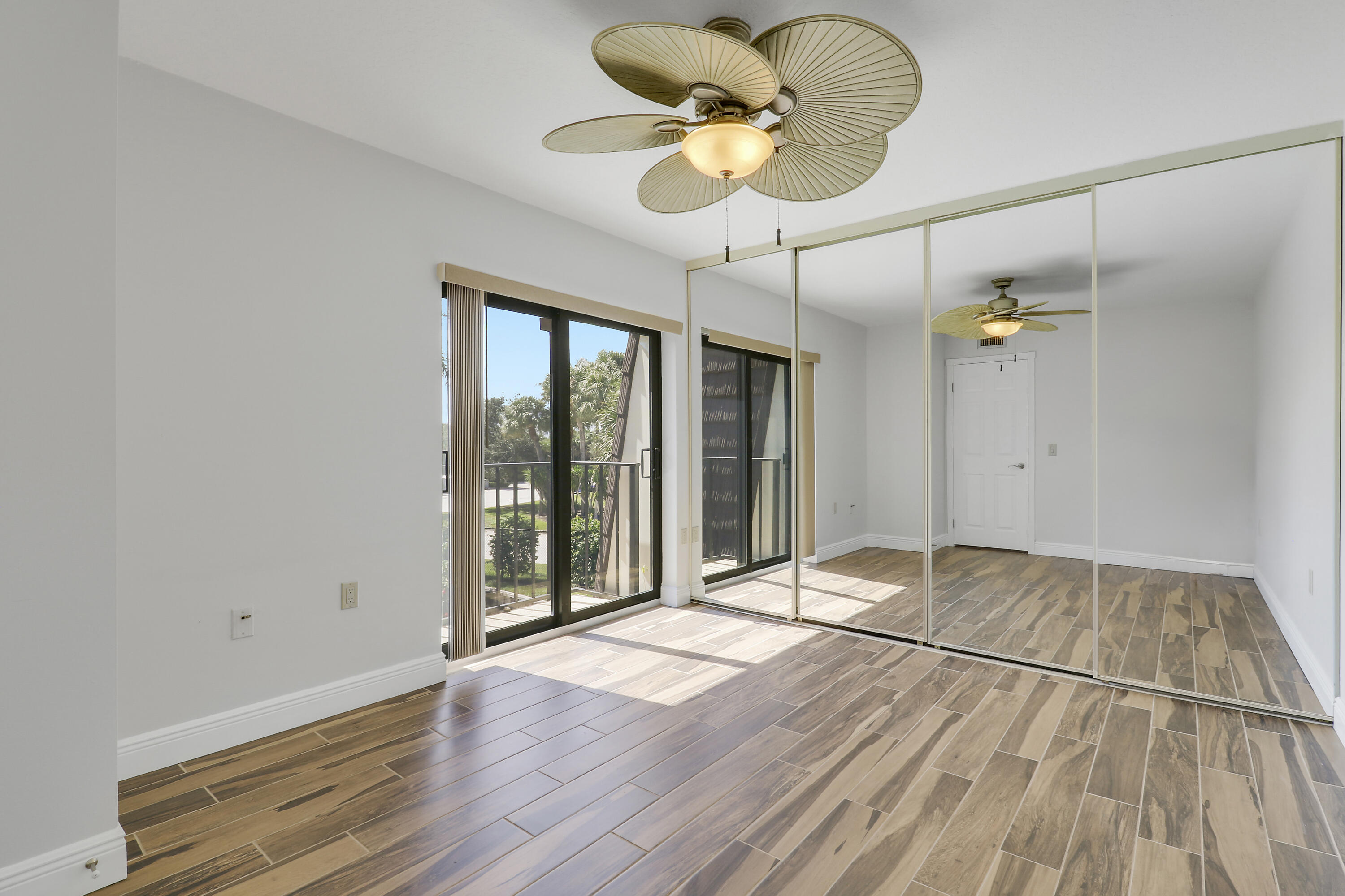 2324 23rd Court, Unit 55D Jupiter, FL 33477 - Photo 25 of 41 a view of an empty room with a window and wooden floor