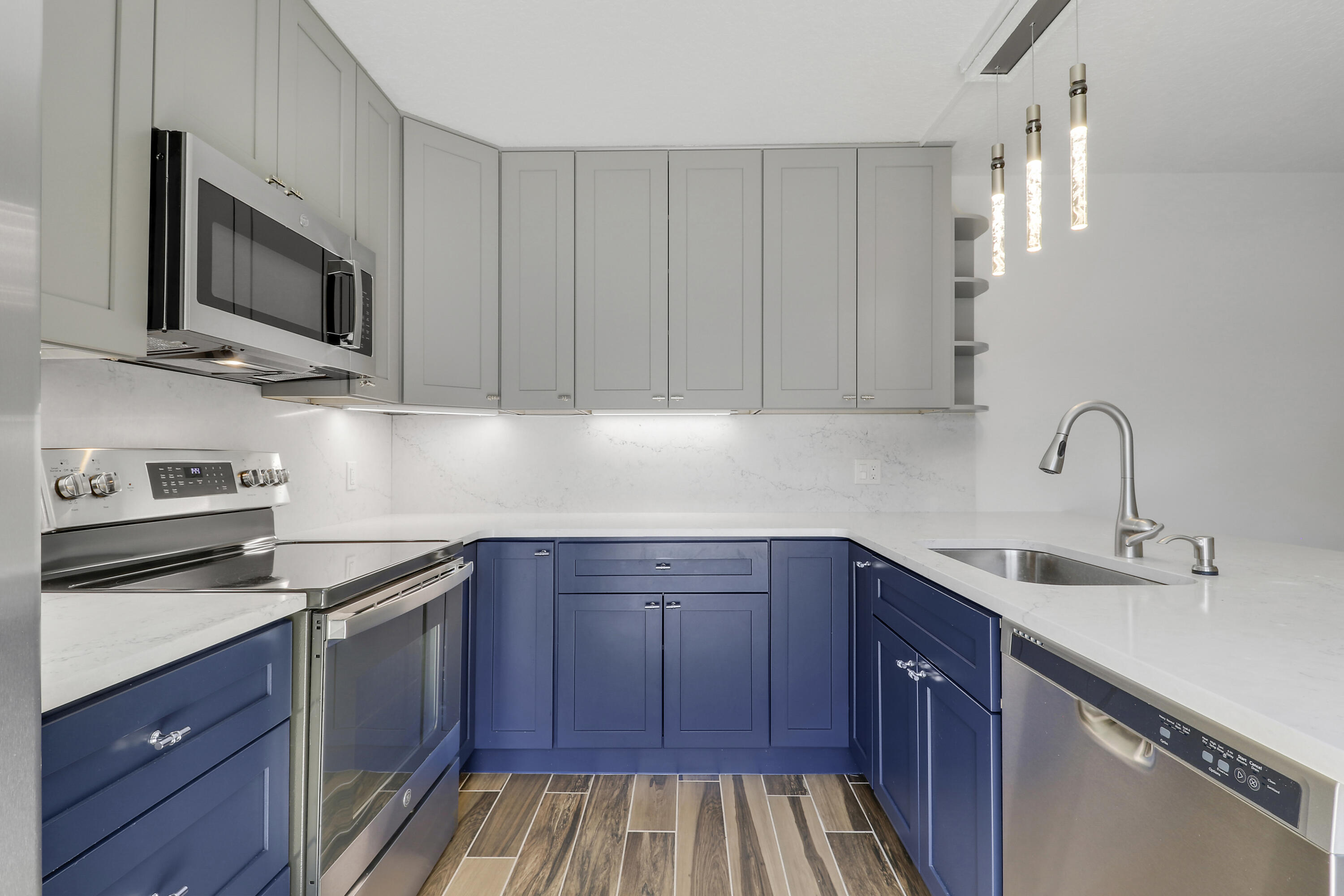 2324 23rd Court, Unit 55D Jupiter, FL 33477 - Photo 4 of 41 a kitchen with stainless steel appliances granite countertop a sink stove and microwave