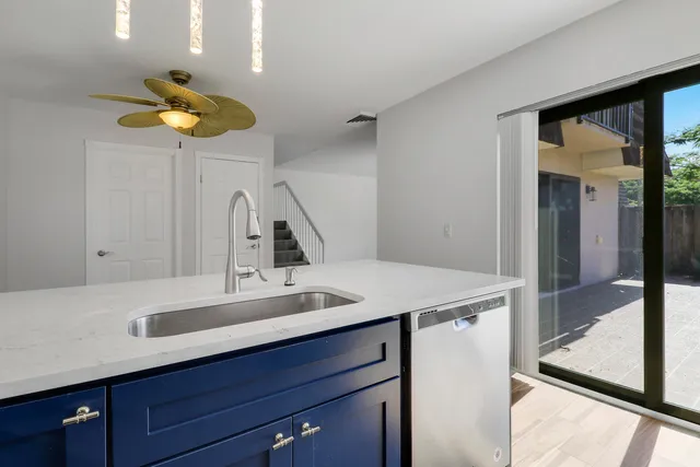 a view of a room with wooden floor ceiling fan and window