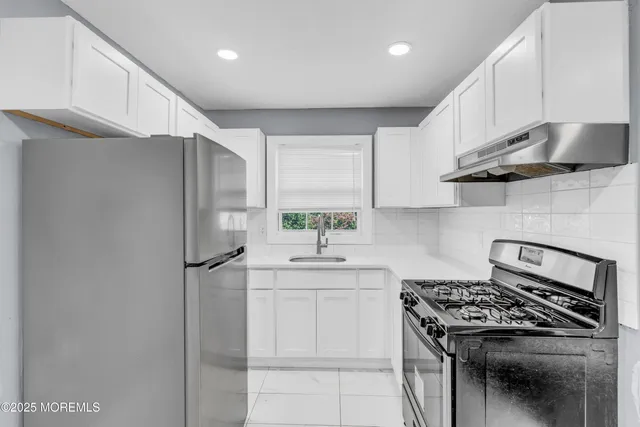 a kitchen with stainless steel appliances a sink stove and refrigerator