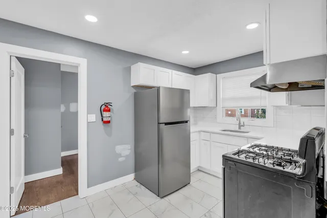 a kitchen with a refrigerator and a stove top oven