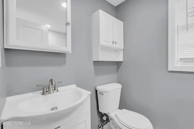 a white toilet sitting next to a bathroom sink
