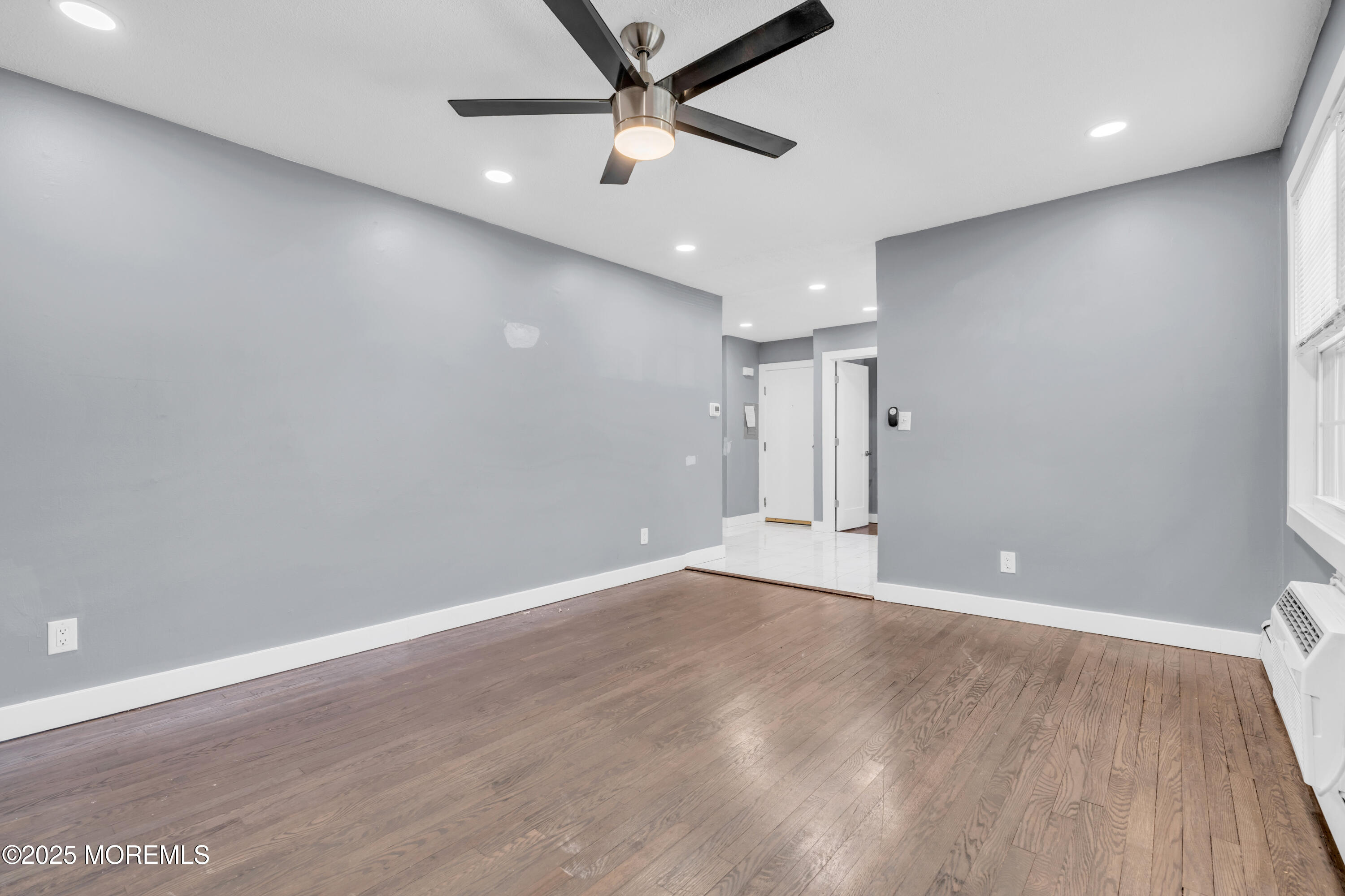 364 Westwood Avenue, Unit 83 Long Branch, NJ 07740 - Photo 10 of 17 an empty room with wooden floor and windows