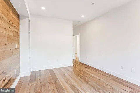 a view of a room with wooden floor and bench