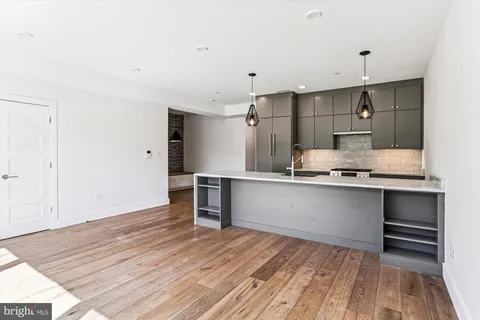 a large kitchen with a wooden floor and stainless steel appliances